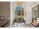 Grand foyer featuring a decorative front door with transom windows, marble floors, and elegant chandelier at 6725 Polo Dr, Cumming, GA 30040