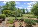 Lush front yard featuring manicured landscaping and mature trees that enhance the curb appeal of the home at 6725 Polo Dr, Cumming, GA 30040