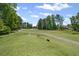 Expansive golf course view with lush green fairway, mature trees, and clear blue skies at 6725 Polo Dr, Cumming, GA 30040