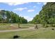 Lush golf course view featuring mature trees and a serene winding path, under a clear blue sky at 6725 Polo Dr, Cumming, GA 30040