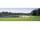 Scenic golf course with a pond, lush green grass, and mature trees creating a serene landscape at 6725 Polo Dr, Cumming, GA 30040