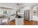 Open kitchen with white cabinets, stainless steel appliances, and view into living area at 6725 Polo Dr, Cumming, GA 30040