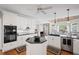 A bright kitchen featuring white cabinets, stainless steel appliances, and hardwood floors at 6725 Polo Dr, Cumming, GA 30040