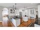 Kitchen with white cabinets, an island, and stainless steel appliances overlooking the living area at 6725 Polo Dr, Cumming, GA 30040