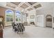 Cozy living room featuring a fireplace, coffered ceilings, natural light, and French door access at 6725 Polo Dr, Cumming, GA 30040