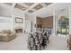 Bright living room features a fireplace, built-in shelves, coffered ceilings, and foyer in view at 6725 Polo Dr, Cumming, GA 30040