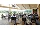 The covered patio features tables and chairs, perfect for enjoying the golf course view at 6725 Polo Dr, Cumming, GA 30040