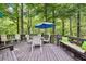 Inviting back deck surrounded by lush trees and an outdoor dining area with seating for eight at 989 Pinfeather Ct, Lawrenceville, GA 30043