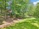 Spacious backyard featuring a lush lawn, mature trees, and a cozy deck at 989 Pinfeather Ct, Lawrenceville, GA 30043
