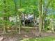 Beautiful backyard with a large deck, mature trees, and professional landscaping with tiered retaining walls at 989 Pinfeather Ct, Lawrenceville, GA 30043