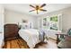 Bright bedroom with hardwood floors, a ceiling fan, and large windows with plantation shutters at 989 Pinfeather Ct, Lawrenceville, GA 30043