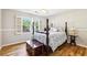 Charming bedroom with hardwood floors, wainscotting, and large windows with plantation shutters at 989 Pinfeather Ct, Lawrenceville, GA 30043