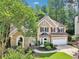 Charming two-story home featuring a stone accent wall, manicured lawn, and attached two-car garage at 989 Pinfeather Ct, Lawrenceville, GA 30043