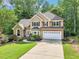 Beautiful home features a stone facade, manicured lawn, shutters, and a two-car garage at 989 Pinfeather Ct, Lawrenceville, GA 30043