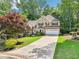 Inviting two-story home with lush front yard, long driveway, shutters, and attached two-car garage at 989 Pinfeather Ct, Lawrenceville, GA 30043