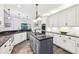 Modern kitchen features an island with a gas cooktop, stainless steel appliances, and white cabinets at 989 Pinfeather Ct, Lawrenceville, GA 30043