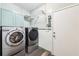 Convenient laundry room with modern, stainless steel washer and dryer set and overhead shelving at 989 Pinfeather Ct, Lawrenceville, GA 30043