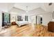 Spacious main bedroom featuring hardwood floors, trey ceiling, sitting area, and ensuite bath and walk-in closet at 989 Pinfeather Ct, Lawrenceville, GA 30043
