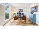 Bright office space featuring hardwood floors, large window, and a classic wooden desk with views of the landscaped yard at 989 Pinfeather Ct, Lawrenceville, GA 30043