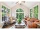 Bright sunroom with vaulted ceilings, a view of the woods, and a comfortable seating area at 989 Pinfeather Ct, Lawrenceville, GA 30043