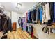 Organized walk-in closet with multiple shelves, hanging rods, and hardwood floors, offering ample storage space at 989 Pinfeather Ct, Lawrenceville, GA 30043
