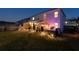 Enjoy the evening ambiance of this backyard featuring landscape lighting, a screened porch, and a relaxing hot tub at 146 Citrine Way, Acworth, GA 30101