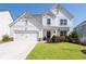 Charming two-story farmhouse-style home with white siding, a manicured lawn and beautiful landscaping at 146 Citrine Way, Acworth, GA 30101