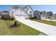 Attractive two-story farmhouse-style home with a long driveway, a lush green lawn, and colorful landscaping at 146 Citrine Way, Acworth, GA 30101