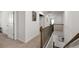 Open hallway with carpet flooring, white walls and trim, and wooden railing around stairs at 146 Citrine Way, Acworth, GA 30101