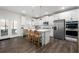 Spacious kitchen features white cabinetry, a center island, stainless steel appliances, and access to the patio at 146 Citrine Way, Acworth, GA 30101
