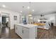 Open kitchen layout with white cabinets, a center island, stainless appliances, and views to the living area at 146 Citrine Way, Acworth, GA 30101