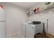 Laundry room with tile floors, washer, dryer, wire shelving, and a refrigerator at 146 Citrine Way, Acworth, GA 30101