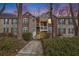 Exterior of a multi-Gathering condominium building with brick and siding, front entrance and landscaping at dusk at 384 Teal Ct, Roswell, GA 30076
