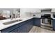 Modern kitchen with stainless steel appliances, granite countertops, and white and blue cabinets at 384 Teal Ct, Roswell, GA 30076