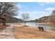 Scenic lake view with a paved walking path, bench, and sparse winter foliage at 384 Teal Ct, Roswell, GA 30076