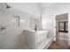 Bright bathroom features a soaking tub with marble tile surround and separate shower at 3850 Laurel Nw Dr, Acworth, GA 30101