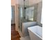 Contemporary bathroom with a glass-enclosed shower and soaking tub with tiled surround at 3850 Laurel Nw Dr, Acworth, GA 30101