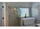 Bright bathroom featuring a soaking tub, glass shower, and neutral tile surround at 3850 Laurel Nw Dr, Acworth, GA 30101
