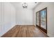 Bright dining room featuring wood floors, paneled walls, and stylish modern lighting at 3850 Laurel Nw Dr, Acworth, GA 30101