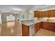 Open kitchen with wooden cabinets and stainless steel dishwasher looking to the open living and dining area at 509 Sawnee Corners Dr, Cumming, GA 30040