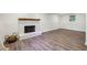 Spacious basement with faux wood flooring, a white brick fireplace, and modern wainscoting detail at 125 Roswell Farms Ln, Roswell, GA 30075