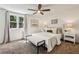 Bright bedroom with a ceiling fan, neutral decor, bedside tables, and a large window overlooking greenery at 125 Roswell Farms Ln, Roswell, GA 30075