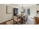Dining room with light-colored walls, wood floors, white framed door, black display cabinet, and a modern light fixture at 125 Roswell Farms Ln, Roswell, GA 30075