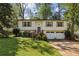 Charming two-story home with manicured front lawn, mature trees, and attached two-car garage at 125 Roswell Farms Ln, Roswell, GA 30075