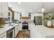 Modern kitchen with white cabinets, stainless steel appliances, and wood accent wall at 125 Roswell Farms Ln, Roswell, GA 30075