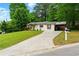 View of the house from a long driveway with a carport and green lawn at 2804 Hall Se Dr, Smyrna, GA 30082