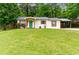Charming home with a bright green front door and a covered carport, surrounded by a lush lawn at 2804 Hall Se Dr, Smyrna, GA 30082