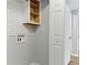 Laundry room features white tiled walls and a storage cabinet; practical and functional at 2804 Hall Se Dr, Smyrna, GA 30082