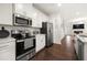 Kitchen featuring quartz counters, stainless appliances, white cabinets, and hardwood floors at 813 Ambient Sw Way, Atlanta, GA 30331