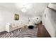Spacious living room with a modern chandelier, zebra print rug, and large sectional sofa at 813 Ambient Sw Way, Atlanta, GA 30331